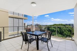 a dining room with a table and chairs on a balcony at Redvue Holiday Apartments in Redcliffe