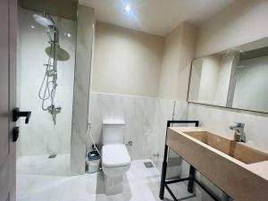 a bathroom with a toilet and a shower and a sink at Unique apartment 