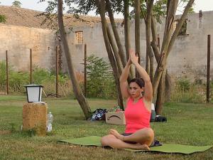 a woman sitting in a field doing a yoga pose at GIARDINO del MARE in Petrosino