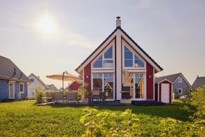 een huis met een schuin dak en glazen ramen bij Schorfheide - Ferienhaus mit Sauna und Hot Tub Whirlpool! Energiekosten flat in Wandlitz