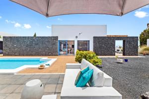 een villa met een zwembad en een patio bij Villalia Nerea in Playa Blanca