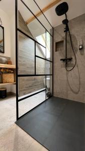 a bathroom with a shower and a glass door at CHAMBRES D'HÔTES LES CHAMBRES D'ELSA in Albiez-Montrond