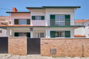 a house behind a brick wall with a gate at NVidas in Figueira da Foz