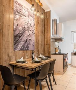 een eetkamer met een houten tafel en stoelen bij Budapest Then & Now Apartment in Boedapest