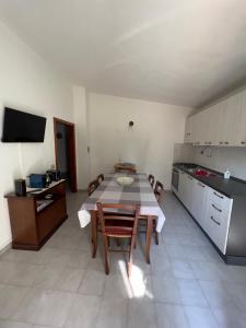 uma cozinha com mesa e cadeiras num quarto em Putzurile House em Orosei