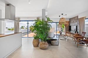 een keuken en een woonkamer met potplanten bij Villalia Nerea in Playa Blanca