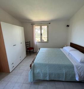 una camera con un grande letto e una finestra di Putzurile House a Orosei