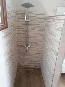 ein Bad mit einer Dusche und einer Fliesenwand in der Unterkunft LA Marina Beach I in Arrieta
