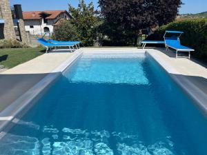 una piscina blu con due sedie blu di La Casa Blu a Montegrosso dʼAsti