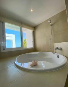 a large bath tub in a bathroom with a window at Ibiza 7th Heaven Villa in Sant Josep