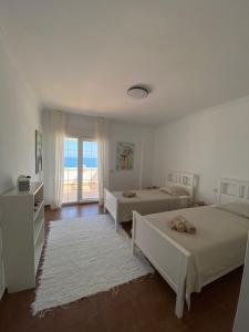 1 dormitorio con 2 camas y ventana grande en Villa Las Americas en Sotogrande