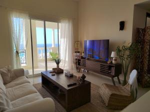 a living room with a couch and a flat screen tv at House 369 in Ras al Khaimah