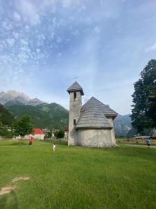 a small building in the middle of a field at Guesthouse Kroni I Micanit in Theth