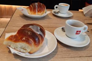 a table with two plates of bread and a cup of coffee at Appartamento Nautes in San Benedetto del Tronto