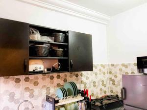eine Küche mit einer Theke mit Tellern und Geschirr auf einem Regal in der Unterkunft Beautiful Studio -3 mins walk to the Beach in Lagos