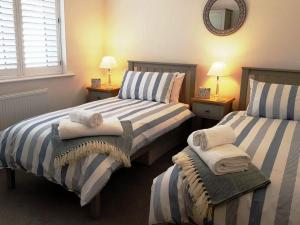 - une chambre avec 2 lits et des serviettes dans l'établissement Beachfront 2 bed lux apart Milford on Sea, The New Forest, à Milford on Sea