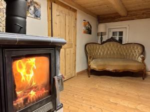 a fireplace in a living room with a couch at Fewo Frushi mit Whirlpool, Infrarotsauna in Großschönau