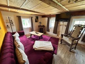 a living room with a purple couch and a table at Fewo Frushi mit Whirlpool, Infrarotsauna in Großschönau