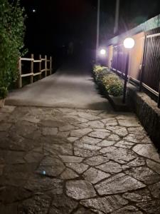 a stone walkway at night with street lights at Green & Blue House in Valbrona
