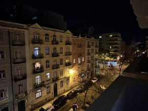 a large building with cars parked in front of it at night at SÓLO HABITACIÓN GRANDE CON BALCOn in Lisbon