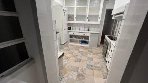 a kitchen with white cabinets and a tiled floor at SÓLO HABITACIÓN GRANDE CON BALCOn in Lisbon