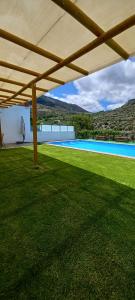 un ampio cortile con piscina e un grande ombrellone di Casa Roma a Granada