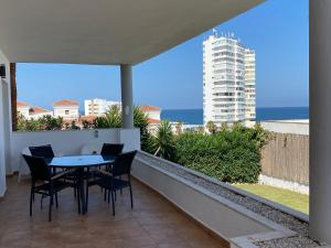 una mesa y sillas en un balcón con vistas al océano en Villa Las Americas en Sotogrande