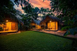 una casa con césped delante en Private Organic House, en Udawalawe