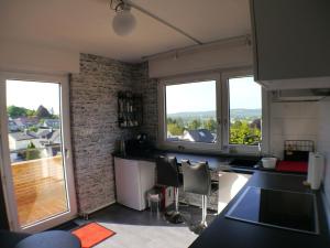 a kitchen with two large windows and a balcony at Siebengebirgsblick in Bonn