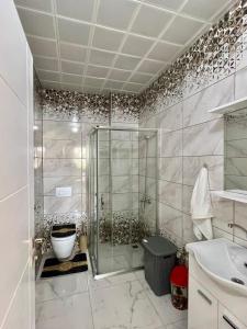 een badkamer met een douche, een toilet en een wastafel bij TURGUT REZİDANS in Bostancı