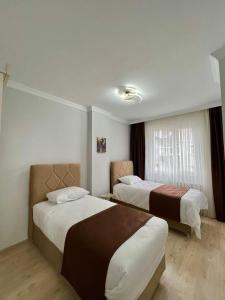 een hotelkamer met 2 bedden en een raam bij TURGUT REZİDANS in Bostancı