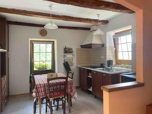 a kitchen with a table and chairs and a kitchen with a sink at CASA DEL CIOS calda e intima casetta immersa nel verde delle montagne in Alpe Basciumo +16 photos
