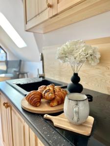 a counter with a plate of croissants and a vase of flowers at Nosal Ski & Wine Apartments in Zakopane