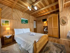 a bedroom with a bed in a wooden cabin at Pokoje u Kasi przy Dol. Chochołowskiej in Witów