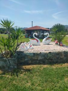 a group of swan statues sitting on a stone wall at Vigla House in Sykia Chalkidikis