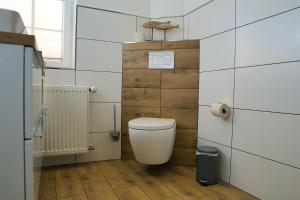 a bathroom with a white toilet in a room at Landhotel Hof Barrl in Schneverdingen