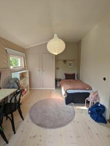 - une chambre avec un lit, une table et un tapis dans l'établissement 30-tals villa med närhet till centrala GBG, à Göteborg