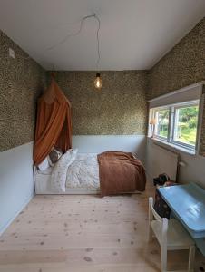 1 dormitorio con cama, ventana y mesa en 30-tals villa med närhet till centrala GBG en Gotemburgo