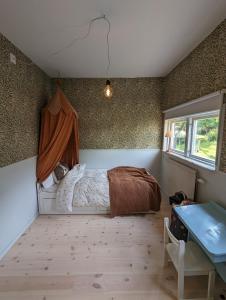 a bedroom with a bed and a window and a table at 30-tals villa med närhet till centrala GBG in Gothenburg