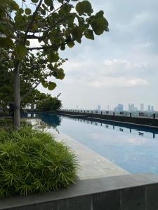 a swimming pool with a city skyline in the background at RoomQu at Apartment Tree Park in Kebonnanas