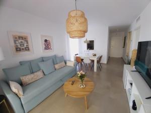 salon z niebieską kanapą i stołem w obiekcie MAR & SAL Roquetas de Mar playa de las Salinas w mieście Roquetas de Mar