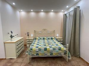 een slaapkamer met een bed en een dressoir bij Casa Vacanze di Laura in Zafferana Etnea