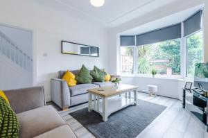 a living room with a couch and a table at SPECIAL RATE FOR BOOKINGS MORE THAN 7 NIGHTS, WARM SPACIOUS CONTRACTOR HOUSE NEAR LIVERPOOL CITY CENTRE SLEEPS 8 kitchen & dining room, washing machine in Liverpool