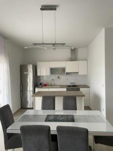 a kitchen with a table with chairs and a refrigerator at Apartman Višić 1692 in Kaštela