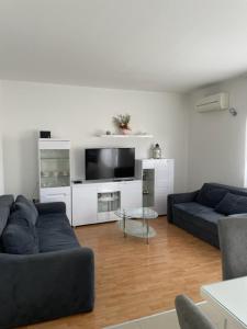 ein Wohnzimmer mit 2 Sofas und einem Flachbild-TV in der Unterkunft Apartman Višić 1692 in Kaštela