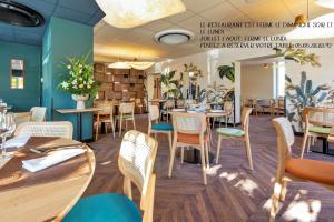 une salle à manger avec des tables et des chaises dans un restaurant dans l'établissement Hôtel Restaurant Le Relais des Gourmands, à Gramat