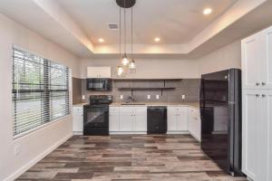 a kitchen with white cabinets and black appliances at Charming 2-Bed Apartment in Houston in Houston