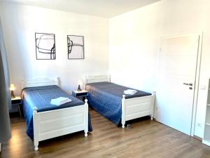 2 Betten in einem Zimmer mit 2 Tischen und einer Tür in der Unterkunft 2 Rooms, free Parking, 25 min to Düsseldorf, 150 Mbps WLAN in Duisburg