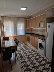 a kitchen with a table and a washer and dryer at Karagoz Apart Pansiyon in Uzungol