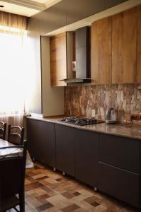 a kitchen with a stove and a counter top at Sweet Home in Yengidzha